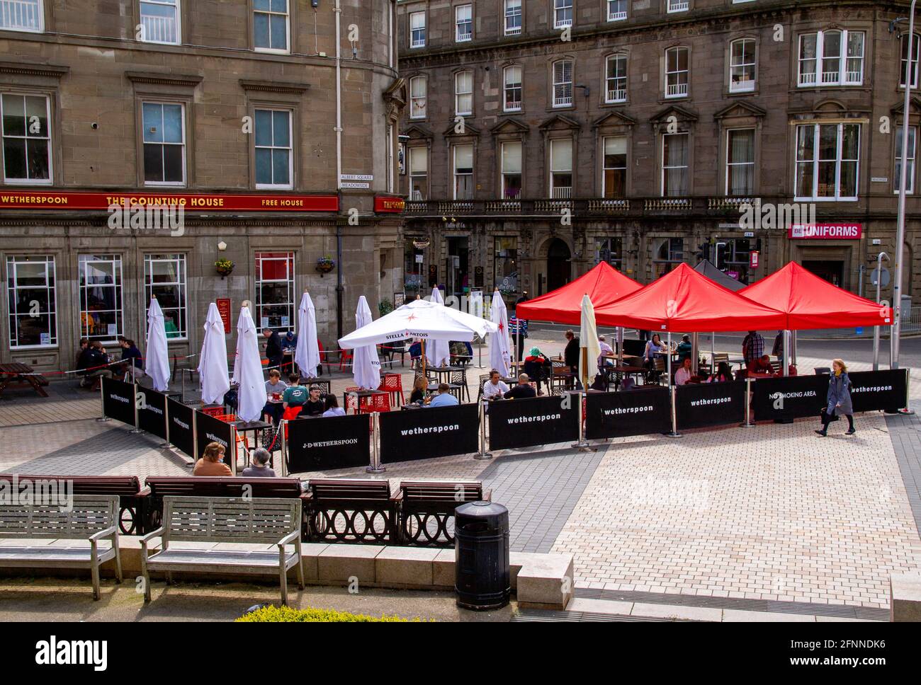 Dundee, Tayside, Scotland, UK. 18th May, 2021. UK Weather: Warm spring sunshine across North East Scotland with temperatures reaching 15°C. Covid-19 lockdown restrictions are now relaxed to Level 2 in Dundee seeing people taking advantage of the new eased regulations and socialising inside and outside local pubs. The Tier 2 restrictions allows Dundee pubs to stay open for business until 10.30pm with customers out enjoying the weather drinking and dining at J.D Wetherspoon`s Counting House public house. Credit: Dundee Photographics/Alamy Live News Stock Photo